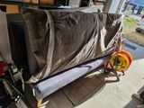 a couch that is covered with a blanket in a garage