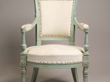 a green chair with white upholstered cushion and wooden legs