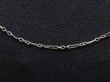 a close up of a silver chain on a black leather surface