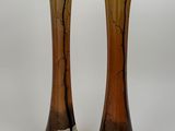 two vases that are sitting side by side on a white surface