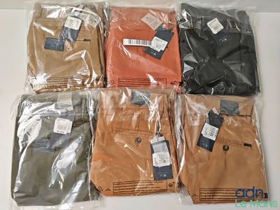 six paires de pantalons pour homme dans des sacs en plastique posés sur une table