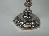a silver candle that is sitting on a white table