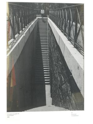 une photo en noir et blanc d'un homme marchant sur un pont