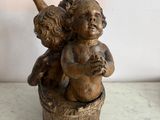 a small statue of a boy and a girl sitting on a barrel