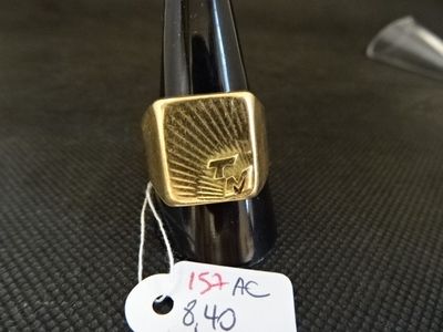 une bague en or avec une étiquette, posée sur une table