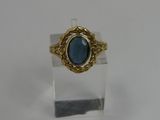 a close up of a ring with a blue stone in it