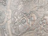 a silver plate with a picture of a man riding a horse on it