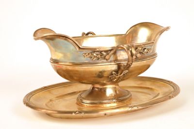 a gold gravy on a tray with a saucer on it