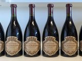 six bouteilles de vin sont alignées sur une étagère