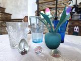 une table sur laquelle sont posés des vases et des verres, avec un mur en pierre en arrière-plan