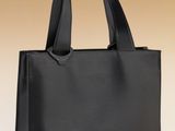 un sac à main noir posé sur une surface blanche