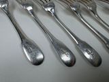 five spoons and six forks sitting on a table