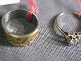 two rings sitting on a table with a red string