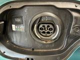 a close up of a car ' s fuel tank with a green car in the background