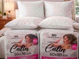 deux oreillers posés sur un lit dans une chambre, près d'une fenêtre