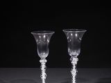 two empty wine glasses sitting on a table with a black background