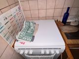 un lave-vaisselle blanc posé sur un plan de travail dans une salle de bains