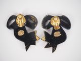 pair of black and gold earrings with gold accents on a white surface