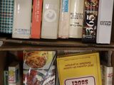 une boîte remplie de livres posée sur une étagère, à côté d'une tasse à café