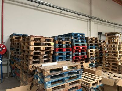 une grande quantité de palettes et de cartons dans un entrepôt