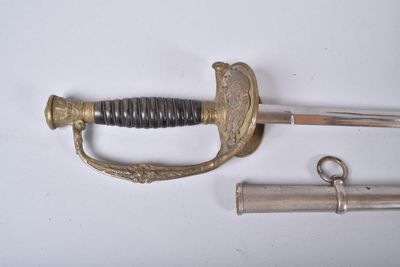 une épée avec une poignée et deux autres objets posés sur une surface blanche