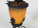 a lamp that is sitting on a stand with a cat on it