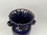a blue vase that is sitting on a white surface