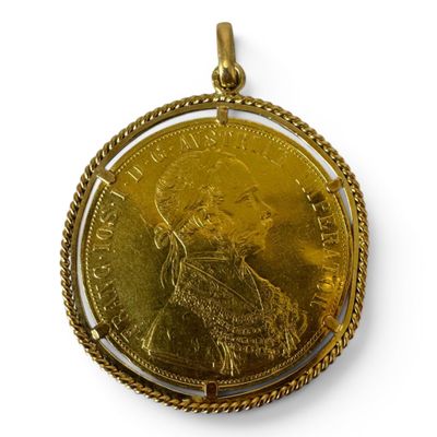 a close up of a gold coin with a chain around it