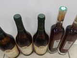 several bottles of wine are lined up on a tile floor