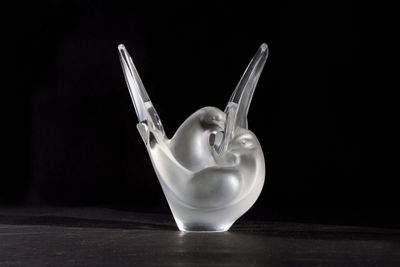 a close up of a glass sculpture of a bird on a table