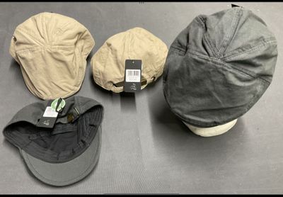 Plusieurs chapeaux sont alignés sur une table, accompagnés d'étiquettes