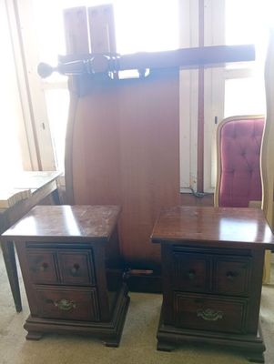 two nightstands with drawers and a chair in the room