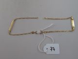 a close up of a gold bracelet with a tag on it