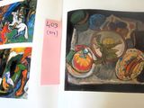 a book opened to show a picture of a painting and a picture of a cat