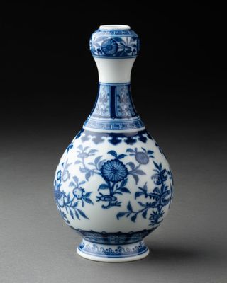 vase bleu et blanc orné de fleurs et de vrilles sur fond noir