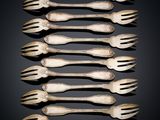 six antique silverware forks and spoons on a black background