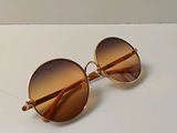 des lunettes de soleil posées sur une table à la surface blanche, sur fond blanc