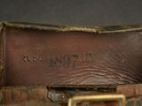 leather belt with the name of a man on it sitting on a table