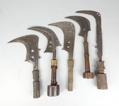 several old knives are lined up on a white surface