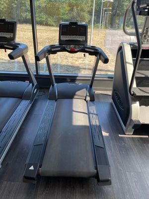 deux appareils de cardio dans une salle de sport donnant sur un champ