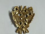a gold brooch with a bird and flowers on it