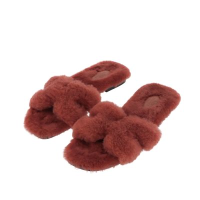 Ces chaussons sont en fourrure de mouton et sont ornés d'un nœud sur le devant.