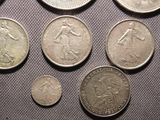 some coins are sitting on a table with a gray cloth
