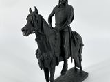 statue représentant un homme à cheval, sur laquelle est posée une lance