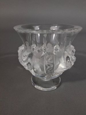 un vase en verre transparent contenant des fleurs, posé sur une table