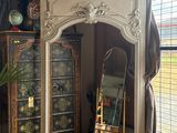 a mirror in the corner of a room next to a dresser