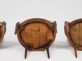 three wooden barrel chairs sitting next to each other on a white surface