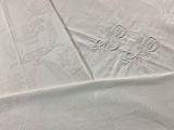 a close up of a white table cloth with a design on it
