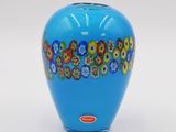 a blue vase with flowers on it on a white surface