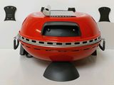 a red bbq with a grill on top of it